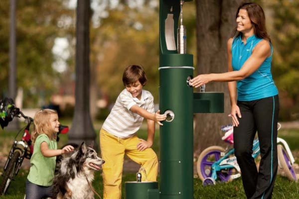Žmonės naudoja geriamojo vandens stotelę lauke